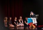 Aktor opiera głowę o stolik z nakrytą rosyjską flagą
