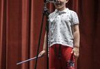 Chłopiec na scenie przemawia do mikrofonu