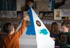 Dzieci malujące kartonową rakietę farbą