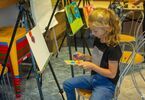 Dziewczynka dotykająca gąbką farb do malowania