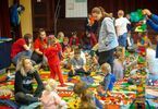 Uczestnicy pikniku - dzieci, animatorzy i rodzice układający wspólnie klocki Lego