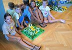 Dzieci zgromadzone wokół budowli z klocków Lego