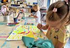 Dzieci skupione na malowaniu swoich obrazów