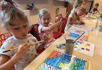 Dzieci skupione na malowaniu swoich obrazów
