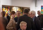 Goście wystawy rozmawiający z malarzem Piotrem Młodożeńcem