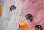 Obraz z kwiatami i fioletowym tłem w procesie powstawania