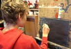 Uczestnik warsztatów podczas tworzenia swojego obrazu malowanego akrylem