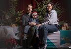 Rodzina pozująca do zdjęcia na świątecznym tle w formie choinek z lampkami, prezentów, siedząca na świątecznym fotelu i pufach DK Zacisze