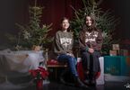 Dziewczyny pozujące do zdjęcia na świątecznym tle w formie choinek z lampkami, prezentów, siedzące na świątecznym fotelu i pufach DK Zacisze