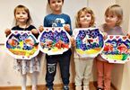 Dzieci trzymające swoje prace - rybki w akwarium wykonane z papieru, kredek i farb