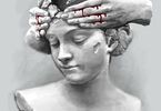 Plakat przedstawiający rzeźbę kobiety, której skronie obejmują inne dłonie, spod których płynie krew