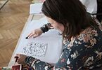 Kobieta tworząca swój rysunek na zajęciach