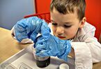 Chłopiec obserwujący próbówkę chemiczną
