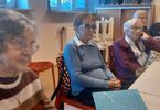Seniorzy siedzą za stołem podczas spotkania
