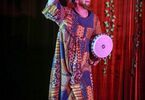 Mężczyzna w kolorowej sukience trzyma afrykański bęben