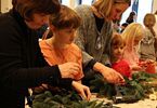 Kobiety i dziewczynki podczas warsztatów florystycznych robienia wianków światecznych