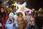 Grupa kobiet i dzieci w kolorowych strojach spaceruje z gwiazdą