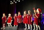 Dzieci w czerwonych sukienkach śpiewają do mikrofonów
