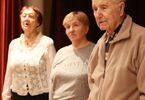 Seniorzy stoją i słuchają hymnu