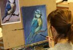 Kobieta maluje pędzlem akrylowego ptaka