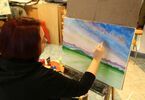 Kobieta maluje obraz farbami akrylowymi