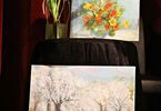 Dwa obrazy, na dole przedstawiający kwitnące drzewa, u góry z kwiatami, obok roślina w doniczce
