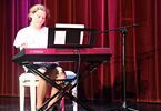 Nastolatka przy pianinie na scenie