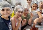 Dzieci w ochronnych czepkach na głowie przy produkcji czekolady