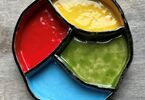 Zdjęcie: Ceramiczny talerzyk, dzielony , żółty, niebieski, zielony i czerwony na szarym blacie