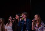 Zdjęcie: pięć śpiewających dziewczyn, trzy z nich z mikrofonem w ręce