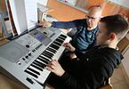 Zdjęcie: Mężczyzna i dziecko przy pianinie elektornicznym