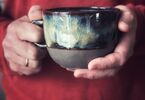 Zdjęcie: Męskie dłonie trzymające filiżankę ceramiczną
