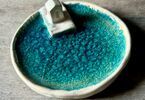 Zdjęcie: Ceramiczna podstawka w kolorze turkusu, beżową lamówką i domkiem ceramicznym