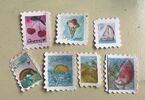 Zdjęcie: siedem znaczków pocztowych z motywem wakacyjnym, namalowane farbami wodnymi
