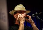 Zdjęcie: Mężczyzna w kapeluszu gra na harmonijce ustnej