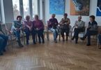 Zdjęcie: Siedzące seniorki uczestniczące na spotkaniu Klubu Podróżnika