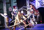 Zdjęcie: grupa performerów w steampunkowych kostiumach wykonująca pokaz akrobatyczny z ogromnymi kołami na scenie