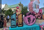 Zdjęcie: instalacja artystyczna w kształcie cyfr 110 z napisem Targówek w Warszawie, w tle wieża kościoła i przechodnie