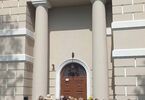 Grupa seniorów stojąca tyłem w kierunku budynku kościoła