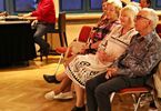 Kobiety i mężczyźni siedzący przed sceną
