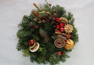 Stroik świąteczny ozdobiony suszonymi owocami i szyszkami