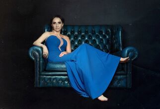 Okładka płyty Renata Krzemyk i mężczyźni. Siedząca na kanapie kobieta, ubrana w długą, niebieską suknię.