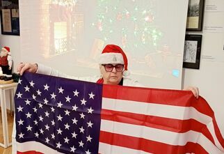 Prowadząca spotkanie trzyma w rękach amerykańską flagę