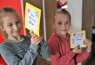 Dziewczynki prezentujące swoje kartki na Dzień Matki
