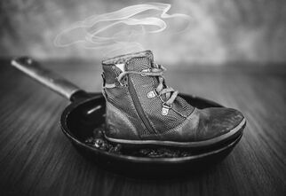 Czarno-biała fotografia z butem na patelni