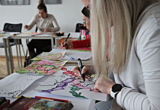 Kobieta tworząca swój rysunek na zajęciach