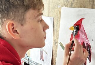 Mężczyzna maluje obraz z ptakiem