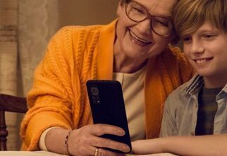 Zdjęcie: Babcia z wnuczkiem przeglądają telefon