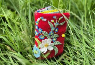 Zdjęcie: Książeczka z filcu z motywem kwiatowym, położona w zielonej trawie