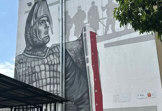 Mural na budynku z rycerzem w zbroi.